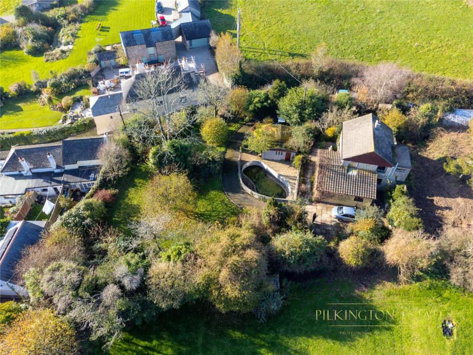 Aerial view of rural house surrounded by green fields